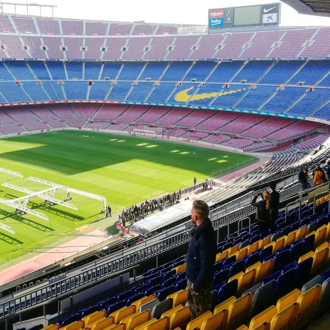 HIGH ANGLE VIEW OF PEOPLE STANDING ON SEAT IN STADIUM