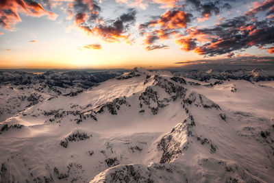 Scenic view of snowcapped mountains against sky during sunset