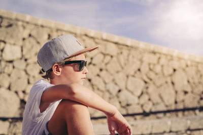 Side view of boy wearing sunglasses against sky