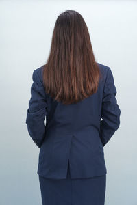 Rear view of woman standing against white background