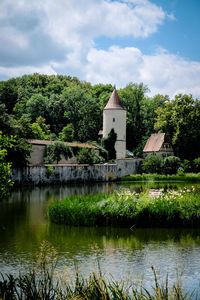 Scenic view of lake by building against sky