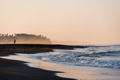 Scenic view of beach against sky during sunrise