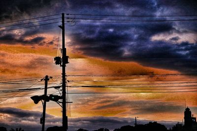 Electricity pylon against cloudy sky