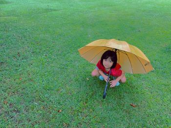 High angle view of girl with umbrella on lawn