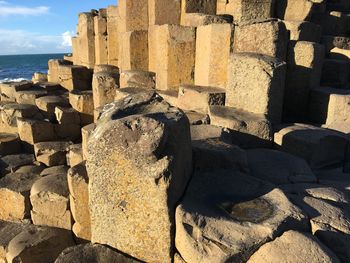 Stone wall by sea against sky