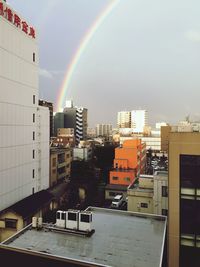 Rainbow over buildings in city