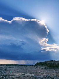 Sunlight streaming through clouds over land