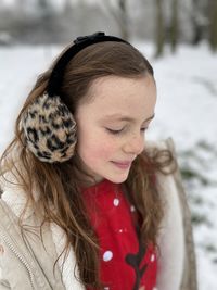 Smiling girl looking down during winter