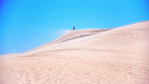 Scenic view of desert against clear blue sky