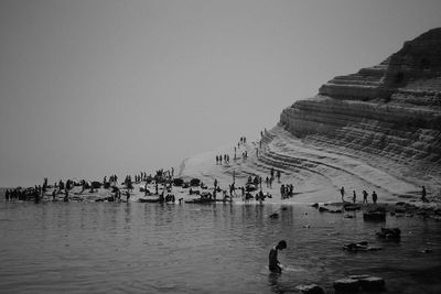People enjoying in water against clear sky