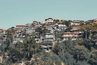 Buildings in town against clear sky