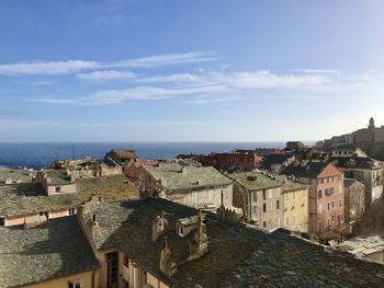 High angle view of townscape by sea against sky