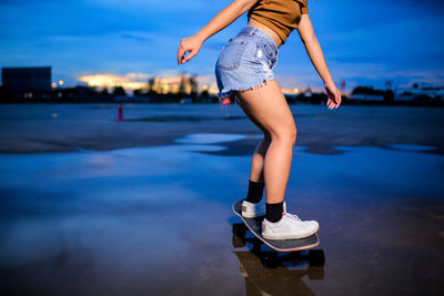 Asian women playing surf skate or skates board outdoors on beautiful summer day. 