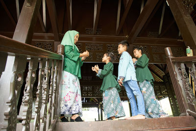 Daughter and son standing in a row greeting mother ask forgiveness during ramadan festival 