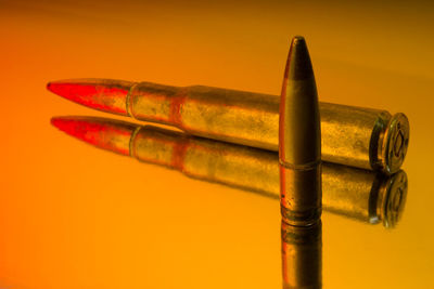 Close-up of pen on table against orange background