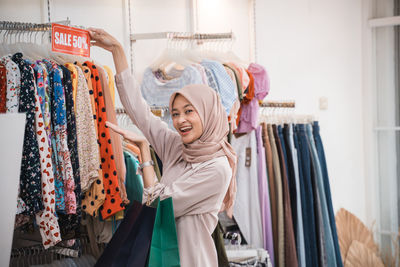 Portrait of young woman standing in shopping mall