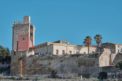 Low angle view of old building against clear blue sky