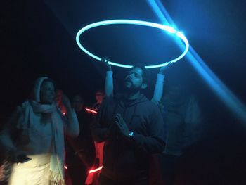 People enjoying in illuminated room at night