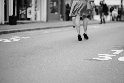 Low section of woman walking on street