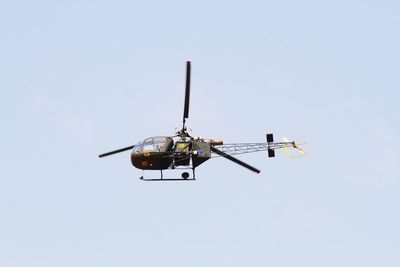 Low angle view of helicopter flying against clear sky