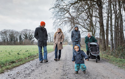 Full length of family walking on road during winter