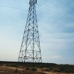 Low angle view of electricity pylon against sky