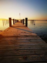 Wooden pier on sea against clear sky