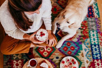 High angle view of woman holding food by dog