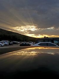 Cars on road against sky during sunset