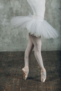 Low section of ballet dancing on wooden floor