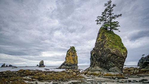 Rock formation on beach against sky