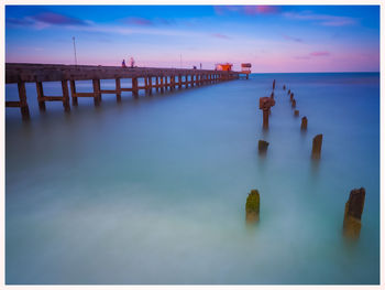 Pier on sea against sky during sunset