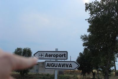 Close-up of road sign against sky