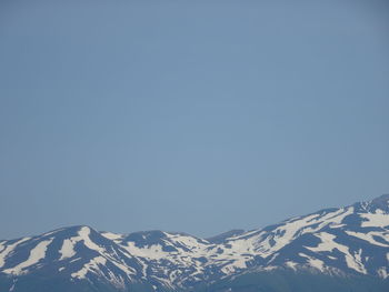 Scenic view of snowcapped mountains against clear blue sky