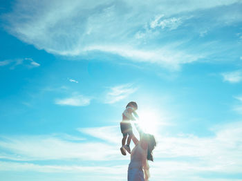 Rear view of woman standing against sky