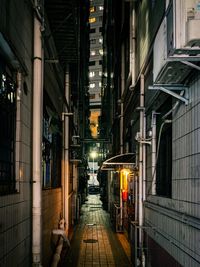 Illuminated street amidst buildings in city at night