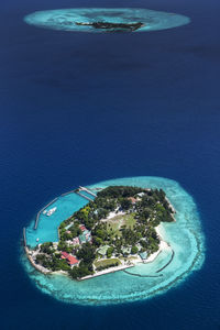 Aerial view from seaplane window house and building over atolls and island at indian ocean, maldives