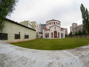 Lawn by building against sky