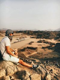 Side view of a man sitting on beach