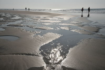 People on beach against sky