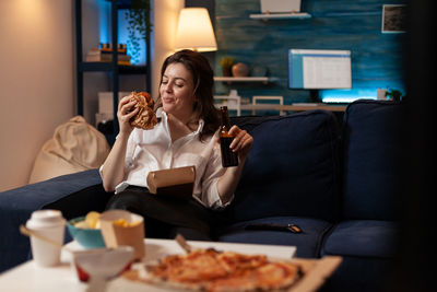 Young woman using mobile phone while sitting at restaurant