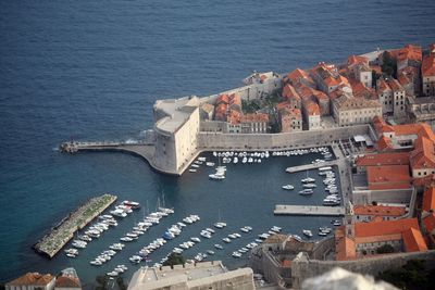 High angle view of townscape by harbor on sea