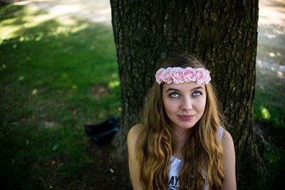 Portrait of teenage girl against tree trunk