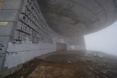 Footpath leading towards wall in city