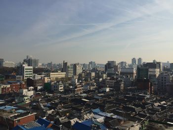 View of cityscape against cloudy sky