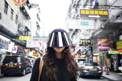 Portrait of female tourist wearing face visor on hong kong street