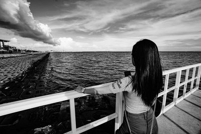 Rear view of woman looking at sea against sky