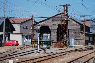 Railroad tracks by buildings in city against sky