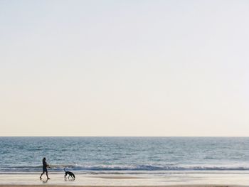 Woman walking with dog at beach