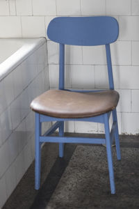 High angle view of empty chairs and table against wall